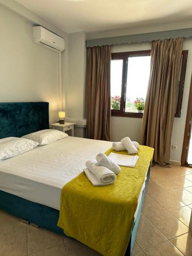a bedroom with a bed with towels on a table at Lixourious Apartment in Lixouri