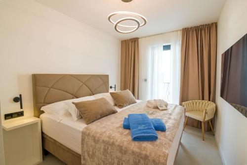 a bedroom with a bed with two blue towels on it at Villa FGstar in Murter