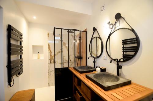 ein Bad mit einem Waschbecken und einem Spiegel in der Unterkunft L'AuthentiK in Guingamp