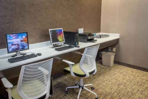 a desk with two monitors and a printer and two chairs at SpringHill Suites by Marriott Denton in Denton