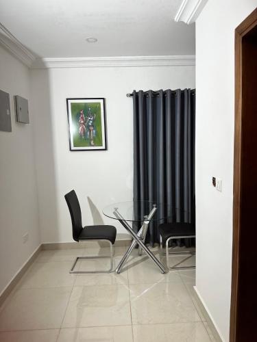 a dining room with a glass table and chairs at Westlands Tower - Ghana Villas in Accra