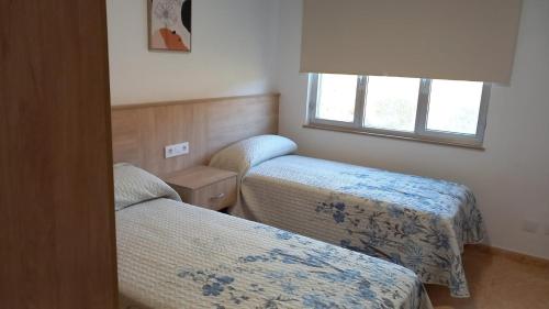 a room with two beds and a window at Beiramar4 in Muxia