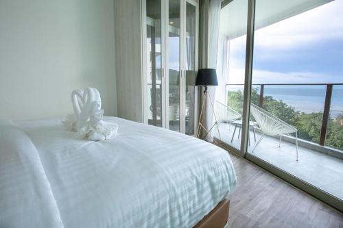 a bedroom with a white bed and a large window at Oceana Phuket A51 in Kamala Beach