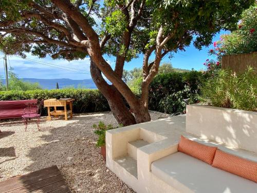 un banc assis sous un arbre à côté d'un arbre dans l'établissement L'Arbousier, à Rayol-Canadel-sur-Mer