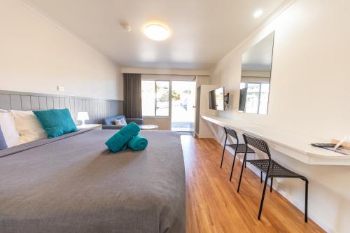 a bedroom with a large bed with two chairs and a desk at Eden Motel in Eden