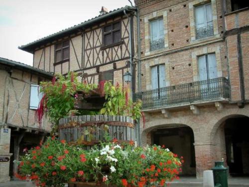 a building with a bunch of flowers in front of it at Au cabanon de Lisle in Lisle-sur-Tarn