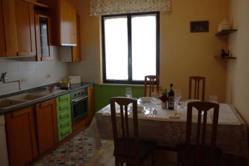 a kitchen with a table with chairs and a window at Apartma SUZY in Koper