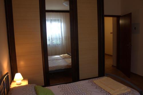 einen Spiegel in einem Zimmer mit einem Bett und einem Schlafzimmer in der Unterkunft Apartma SUZY in Koper