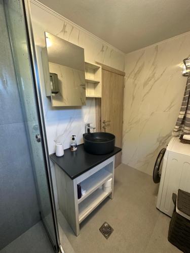 ein kleines Bad mit einem Waschbecken und einem Spiegel in der Unterkunft Maroudio's Villa in Livadáki