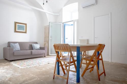 - un salon avec une table, des chaises et un canapé dans l'établissement Senso Unico: nuovo appartamentino in centro, à Bisceglie