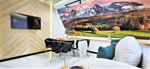 a living room with a tv on a wall at VIP APARTAMENTY Chałubińskiego APART in Zakopane