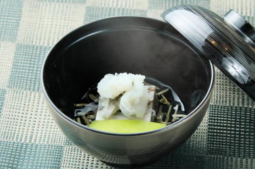 a black bowl with food in it on a table at Tensui Saryo in Hakone