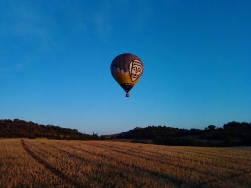 a hot air balloon flying over a field at Cal Ros in Calonge de Segarra