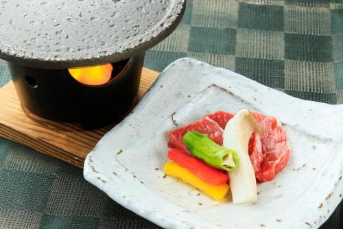 a plate with meat and vegetables on a table at Tensui Saryo in Hakone