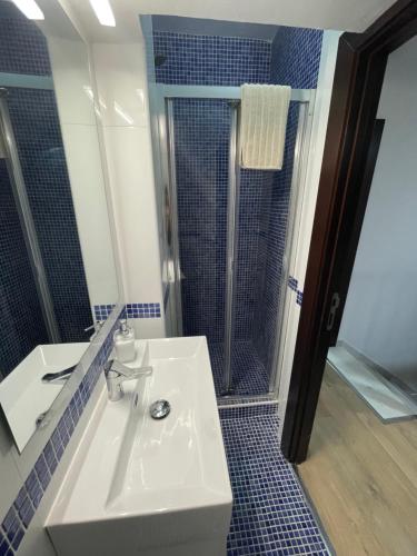 La salle de bains est pourvue d'un lavabo et d'une douche. dans l'établissement Apart 1 en PLANTA BAJA CON PEQUEÑO JARDÍN EN PRIMERA LÍNEA DE PLAYA, à Almería