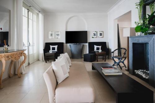 a living room with white furniture and a fireplace at Hotel Carducci 76 in Cattolica