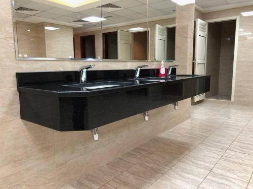 baño con 2 lavabos y espejo grande en Sweet studio in Dubai Sports City, en Dubái