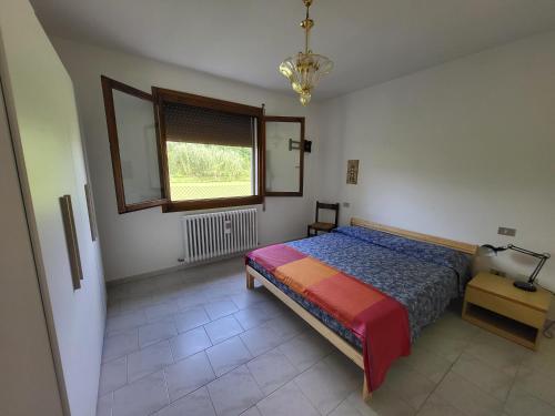 1 dormitorio con cama y ventana en Alloggio indipendente Cesulìn, en Porto Viro