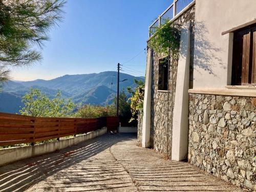 einen Steinweg, der zu einem Gebäude mit einem Zaun führt in der Unterkunft Traditional House with Mountain View - Dierona Village in Dierona