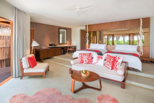 a hotel room with a bed and a couch at W Maldives in Fesdu Island