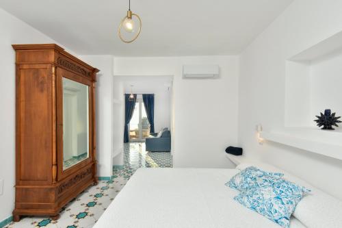 a bedroom with a bed with a dresser and a mirror at Albeca Boutique Hotel - Relais de charme sul mare in Castellabate
