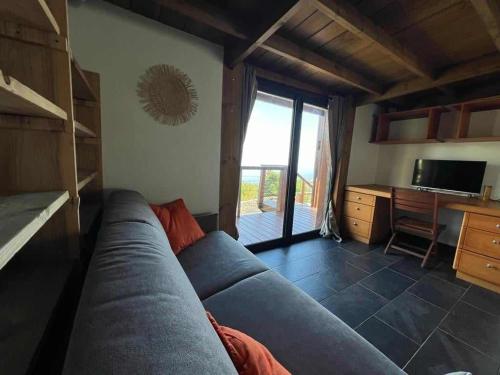 a living room with a blue couch and a television at Villa Maloya in Saint-Leu