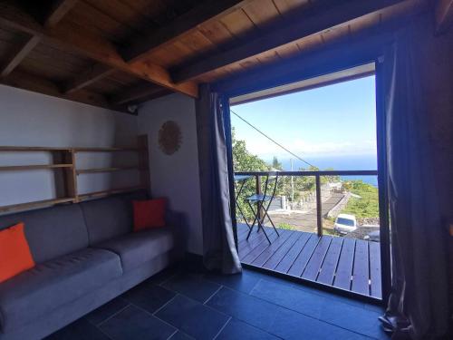 a living room with a couch and a large window at Villa Maloya in Saint-Leu