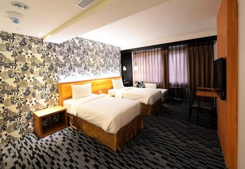 Habitación de hotel con 2 camas y TV de pantalla plana. en Bamboo Hotel, en Kaohsiung