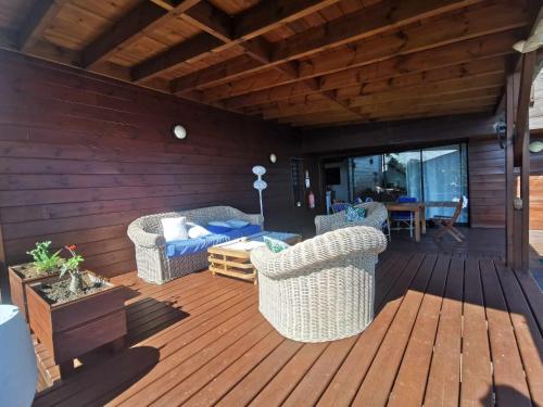 a patio with two chairs and a table on a wooden deck at Villa Maloya in Saint-Leu