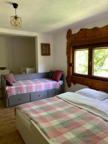 een slaapkamer met 2 bedden en een raam bij Farmstead Green Haven in Mojkovac