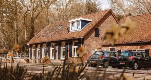 two cars parked in front of a brick building at Hotel 't Welink in Dinxperlo