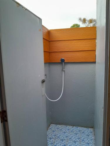 a shower with a hose attached to a wall at Khaolak Banana Bungalow in Khao Lak