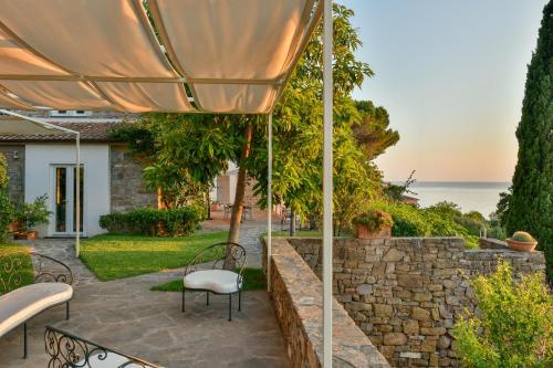 a patio with a table and chairs and an umbrella at Albeca Boutique Hotel - Relais de charme sul mare in Castellabate