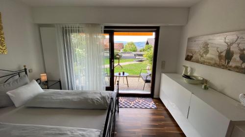 1 dormitorio con 1 cama y puerta que da a un patio en Stilvolle Wohnung in idyllischer Lage, en Bad Säckingen