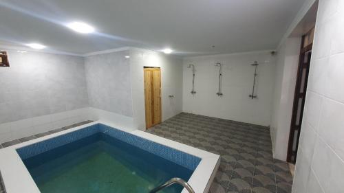 La salle de bains est pourvue d'une grande baignoire bleue. dans l'établissement Agat Yurt Camp, à Kaji-Say