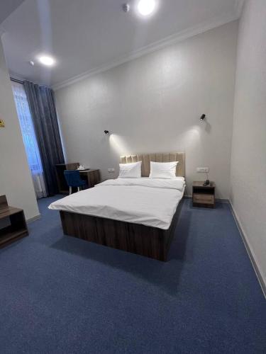 - une chambre avec un grand lit et des draps blancs dans l'établissement Premium 777 Yunusabad, à Tachkent