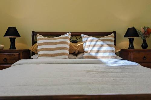 1 dormitorio con 1 cama con almohadas y 2 lámparas en Learmonth Guesthouse - Queenscliff, en Queenscliff