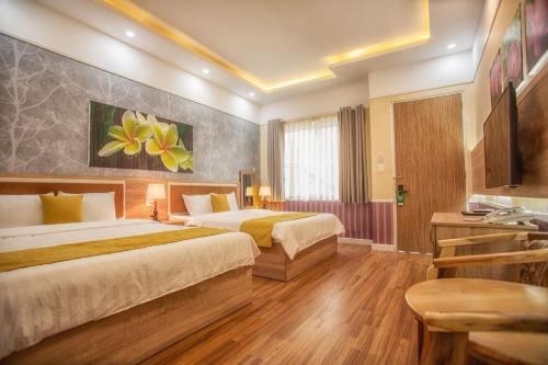 Habitación de hotel con 2 camas y TV en Sao Vang Hotel, en Bao Loc