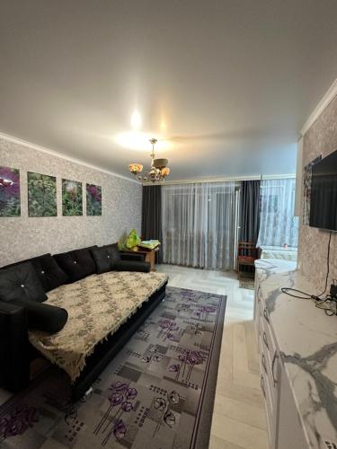 sala de estar con cama y sofá en Квартира Уют en Borovoye