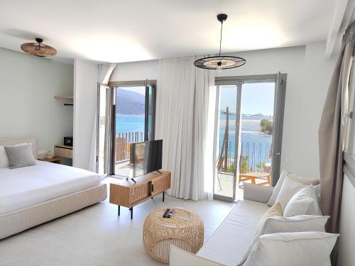 ein Schlafzimmer mit einem Bett und ein Wohnzimmer mit Aussicht in der Unterkunft Trizonia Mare Suites in Trizonía