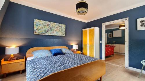 a bedroom with a bed with a blue wall at ArtHouse Am Kurpark Bad Schandau in Bad Schandau