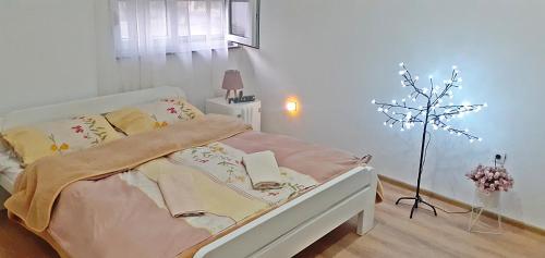 a bedroom with a bed with a lamp and a tree at Spacious, comfortable and peaceful house in Međugorje