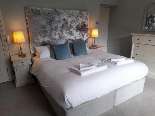 a bedroom with a large white bed with towels on it at Fairwater Head in Axminster