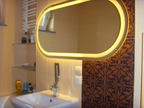 a bathroom with a sink and a mirror on the wall at Apartament na kurzej stopce in Malbork