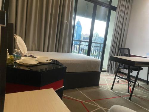 a hotel room with a bed and a table and a desk at Studio Bedroom with Balcony in Kuala Lumpur