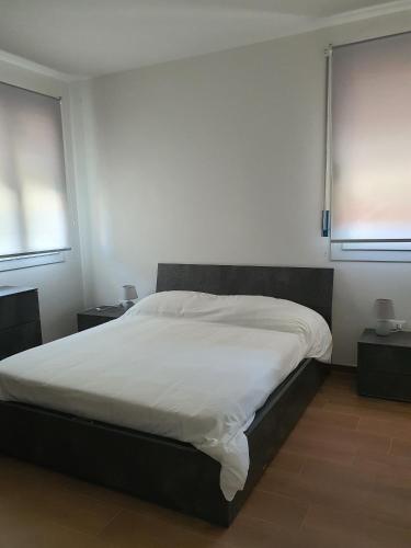 a large bed in a room with two windows at La Casa de Papel - Self Check in, Smart Tv, tutti i confort, appartamento privato non condiviso in Cavarzere