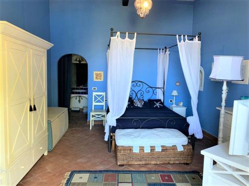 sypialnia z niebieskimi ścianami i łóżkiem z baldachimem w obiekcie La Casa sul Porto di Santa Marina - Isole Eolie w mieście Santa Marina Salina