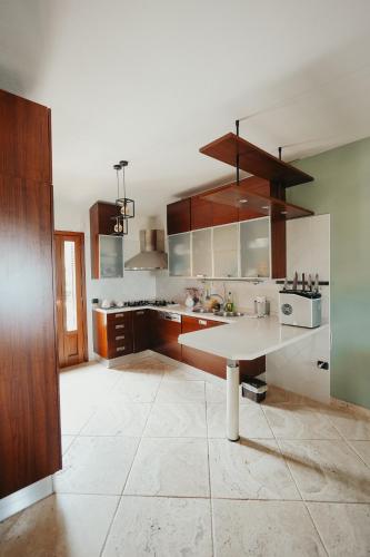 a kitchen with wooden cabinets and a table in it at Villa Alba Sul Mare in Budoni