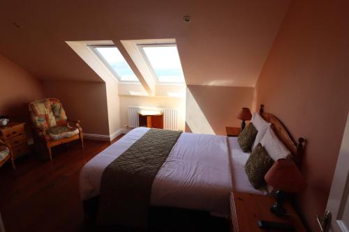 a bedroom with a bed and two windows at The Old Pier Guest Accommodation, bed only, no breakfast in Ballydavid