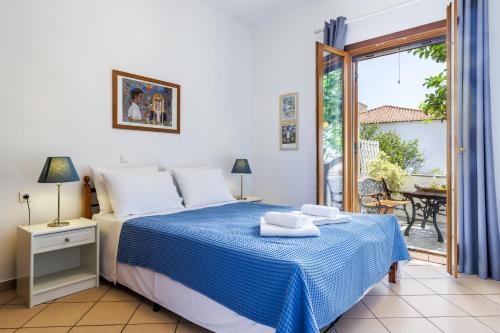 a bedroom with a bed and a balcony with a table at Lemon Casa in Skopelos Town